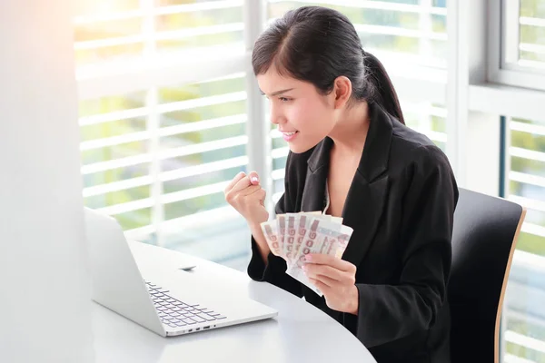 Красива бізнес-леді здивує і тримає банкноти з ноутбуком — стокове фото