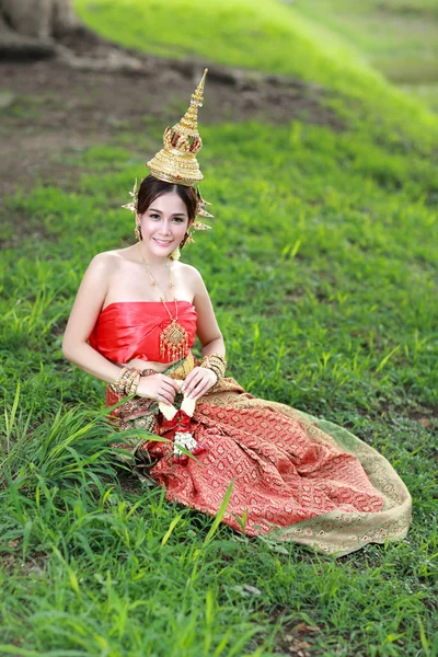 Moda asiático chica en tailandés tradicional traje en antiguo templo con volante flor en la mano — Foto de Stock