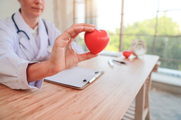 доктор держит и дает красное сердце любви и ухода (этот образ для медицинской концепции
)