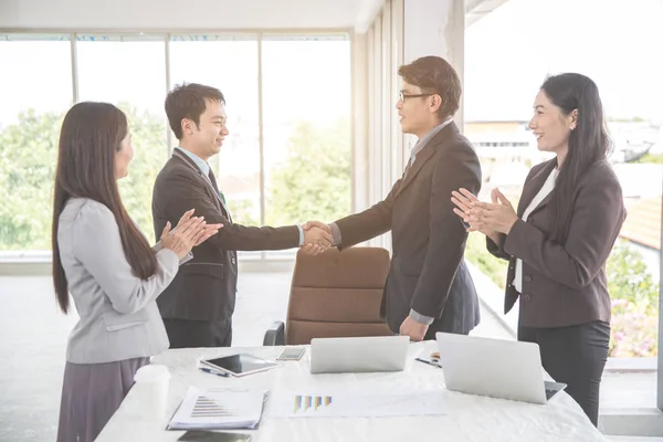 Affärsfolk skakar hand efter avslutade projekt under mötet med som bakgrund (koncept för teamwork och partnerskap) — Stockfoto