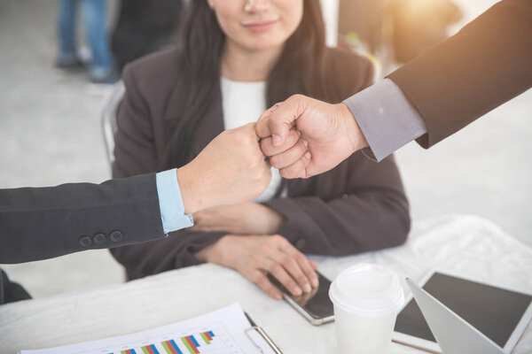 business people giving fist bump after completed project during meeting using as background (concept of teamwork and partnership)