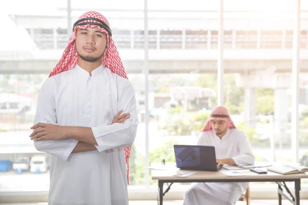 Arabisk saudisk affärsman porträtt med medarbetar bakgrund — Stockfoto