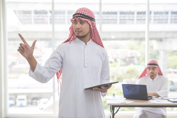 Porträtt av arabisk saudisk affärsman som pekar med anställdas bakgrund — Stockfoto