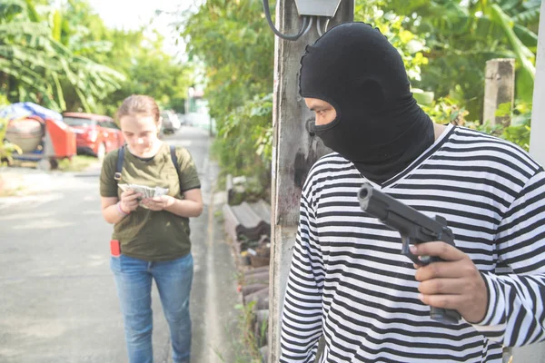 Dieb stiehlt Frau auf der Straße mit Waffe in der Hand Geld) — Stockfoto