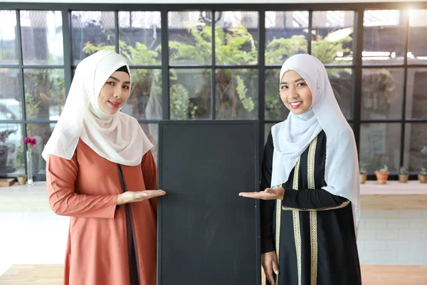年轻的穆斯林女孩展示黑板（你可以在黑板上写上字母）) — 图库照片