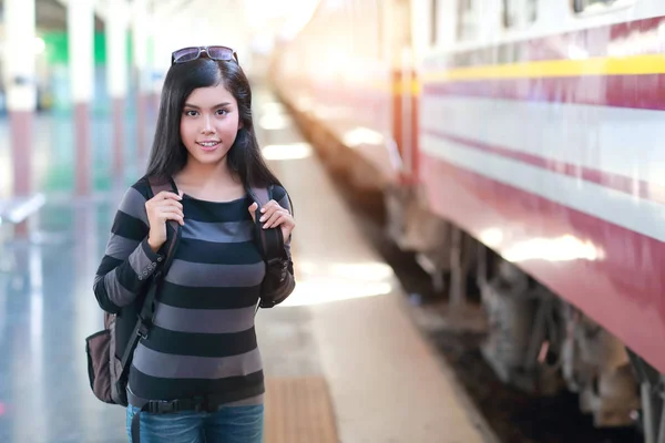 Junge Reisende mit Rucksack wartet auf Zug lizenzfreie Stockfotos