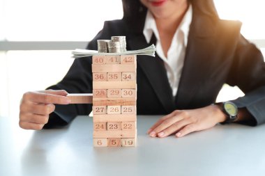 İş kadını para ve sikke ile ahşap blok oyunu oynarken, yönetim stratejisi kavramı fikri