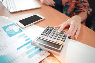 hesap makinesi ve akıllı telefon ve bilgisayar ile çalışan iş kadını