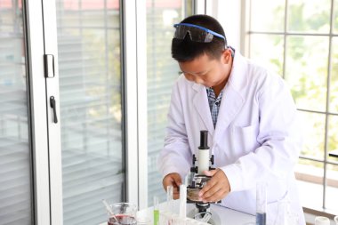 meraklı çocuk çocuk mikroskop ve dikkat yüzü ile bilim deney (eğitim ve bilim adamı kavramı)