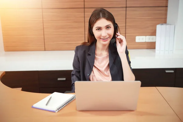 Porträt einer schönen Callcenter-Frau mit Kopfhörer und Computer — Stockfoto