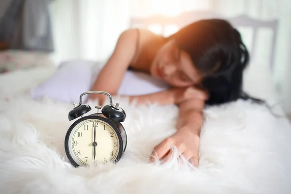 目覚まし時計付きの寝室で眠っている若い女性 — ストック写真