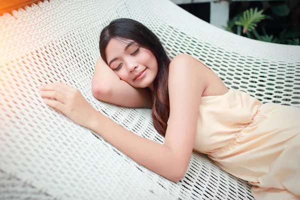 Tatil sırasında bir hamakta uyuyan genç ve sevimli Asyalı kadınlar — Stok fotoğraf
