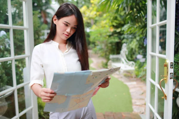 Jovem e bonito asiático mulher procurando localização em um mapa durante as férias — Fotografia de Stock