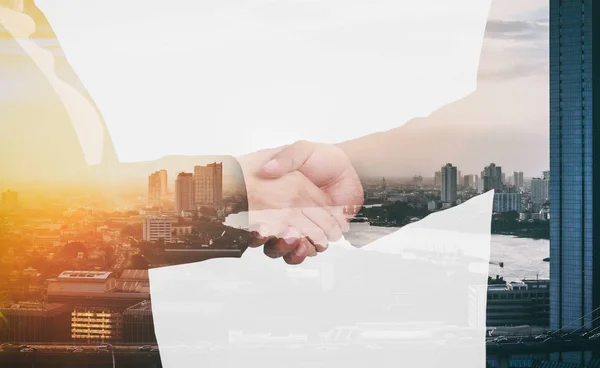 Double exposure of handshake over city view and river with sun light — Stock Photo, Image