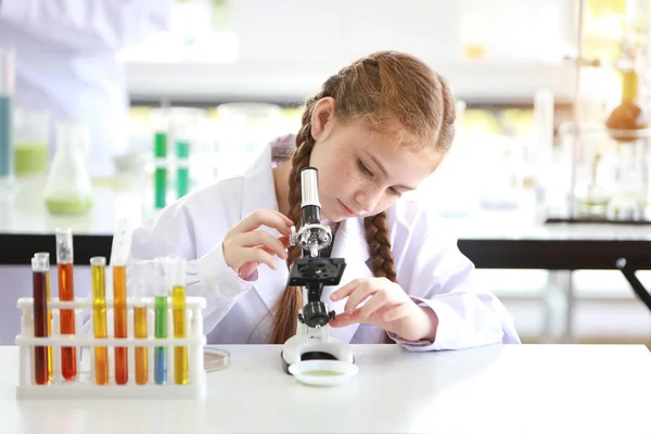 Niña feliz haciendo experimentos científicos con microscopio (educación y concepto científico ) —  Fotos de Stock