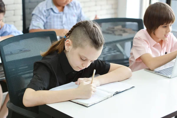 Niño de escuela inteligente escribiendo en clase (concepto de educación ) —  Fotos de Stock