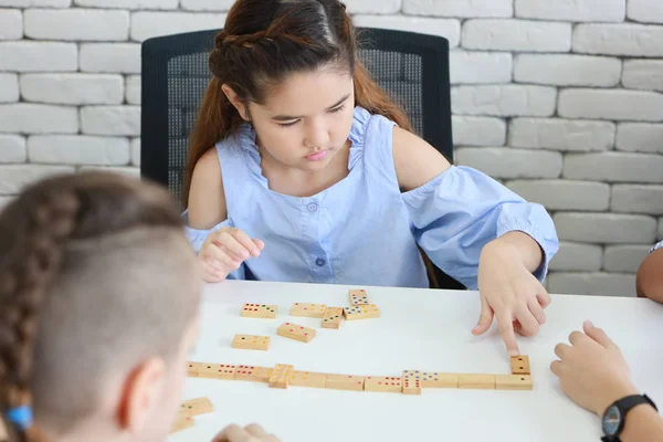 Niedliche und intelligente Kinder, die im Unterricht Domino spielen (Bildungskonzept)) — Stockfoto