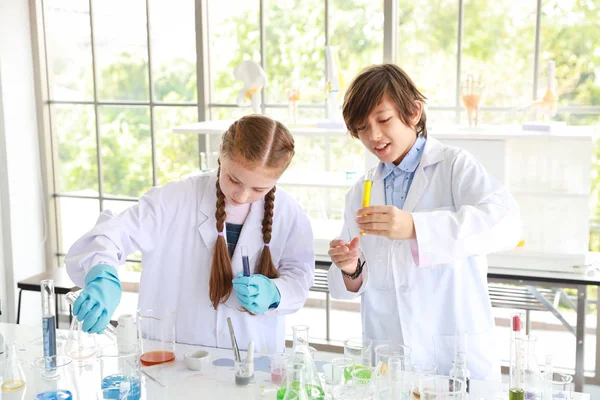 Niños felices haciendo experimentos científicos. (educación y concepto científico) — Foto de Stock