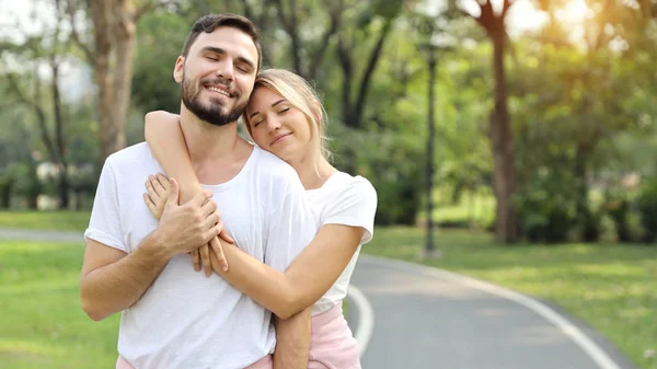 年轻夫妇相爱了夏季在公园里拥抱（友谊或情人节概念）) — 图库照片