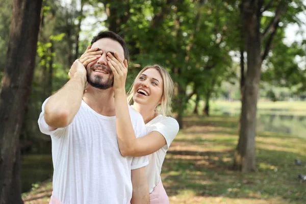 Medium shot, young lovely couple caucasian in white dress playing blindfolded with happy face and laughing in park outdoor during summer — Stock Photo, Image