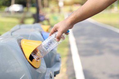adam elleri çöpe boş plastik şişe atmak