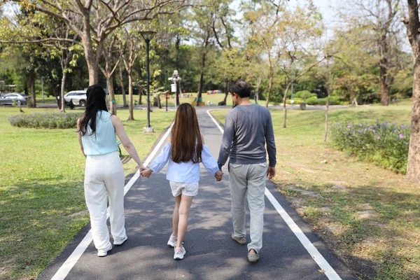 Lyckliga familje föräldrar och barn vilar genom att gå och springa i parken under sommarsäsongen med klarblå himmel och gröna träd — Stockfoto