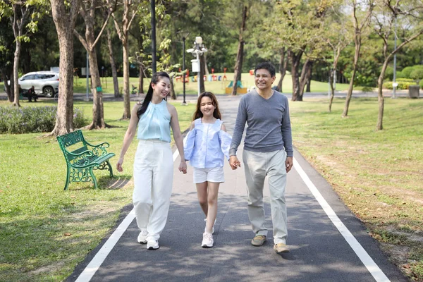 在夏季绿树成荫的时候，快乐的亚洲家庭、父母和孩子们都在公园里散步和跑步来休息 — 图库照片