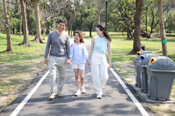 Glückliche asiatische Familie Eltern und Kinder ruhen durch Spaziergänge und Laufen im Park während der Sommersaison grüne Bäume — Stockfoto