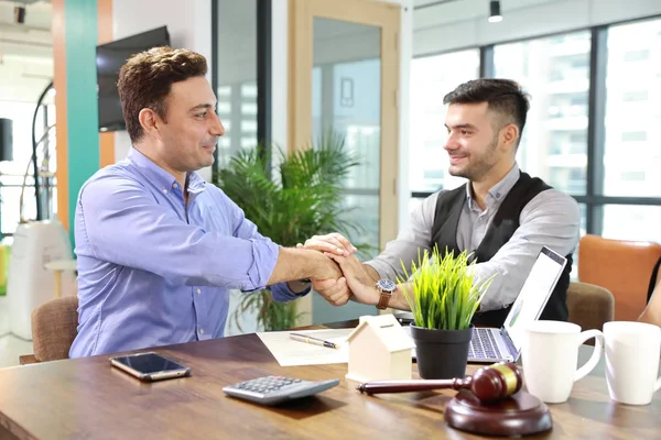 Dois empresários caucasianos de mãos dadas após assinar contrato significado de negócio de sucesso com rosto feliz e sorridente — Fotografia de Stock