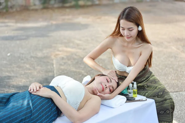 Masaje en la cabeza, vista lateral retrato de dos mujeres asiáticas hermosas y sexys jóvenes, pelo largo con vestido blanco disfrutando del salón de masajes de spa de aceite mientras está acostado durante las vacaciones de verano — Foto de Stock