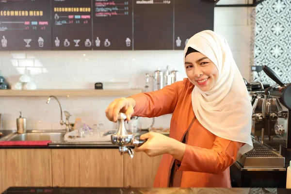 Giovane donna musulmana barista che fa il caffè con il viso sorridente e felice — Foto Stock