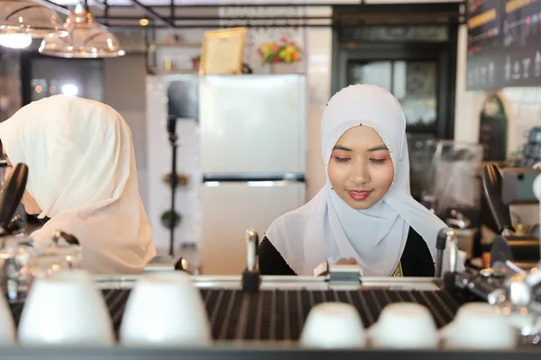 Junge muslimische Barista-Frau macht Kaffee mit Schönheitsgesicht — Stockfoto