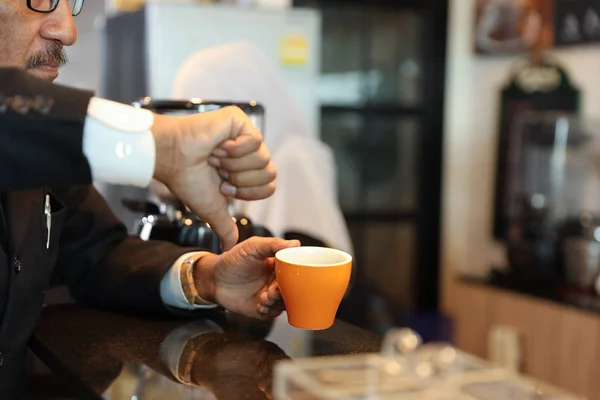 Muslim kund affärsman klädd i svart kostym tummen ner till en kopp kaffe och klaga på Counter med unga muslimska Barista affärskvinna — Stockfoto