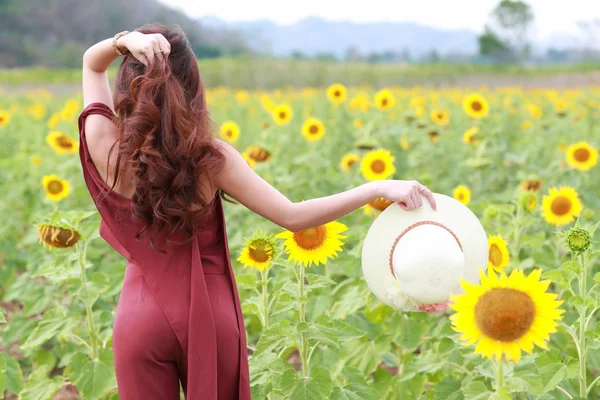 Doğada ayçiçeği tarlası arasında mutlu vakit geçiren ve eğlenen güzel kadının portresi — Stok fotoğraf