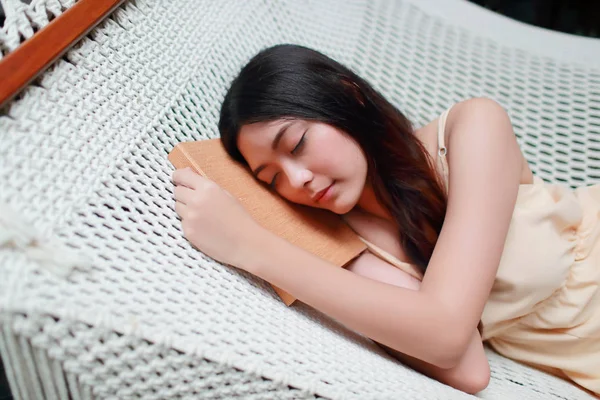 Jong en schattig Aziatisch meisje liggend in een hangmat met boek tijdens Ho — Stockfoto