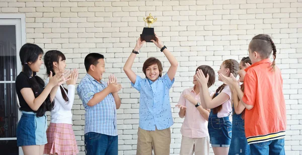 Grupo de niños de la escuela sosteniendo trofeo con la cara sonriente feliz en el aula en la pared blanca (concepto de educación ) — Foto de Stock