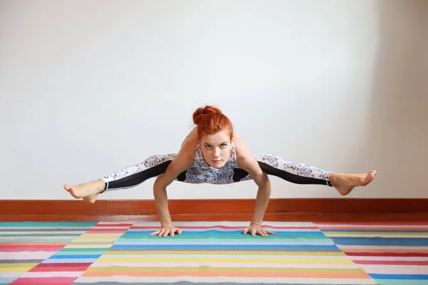 Esportivo jovem mulher caucasiana atraente em preto e branco sportswear praticando ou exercício de ioga interior. equilíbrio entre corpo e mental. (conceito de vida saudável) — Fotografia de Stock