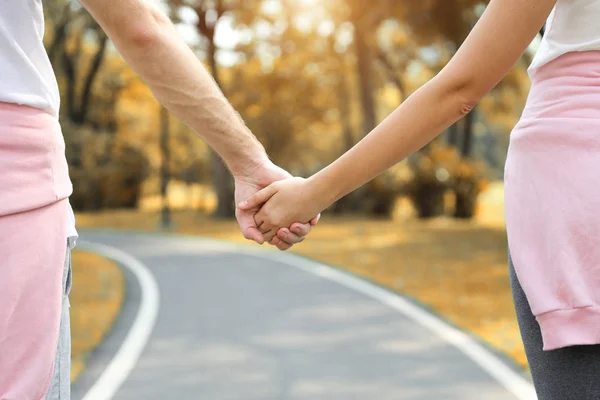 Giovane coppia romantica che si tiene per mano e cammina insieme nel parco in autunno (vacanza o concetto di San Valentino ) — Foto Stock