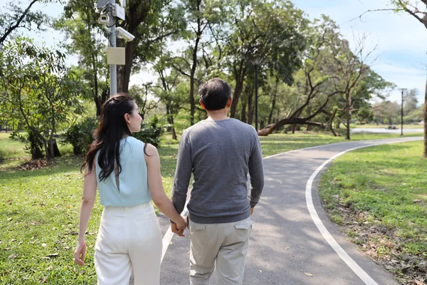 Back View asiatiska par promenader och pratar i parken med Happy Face — Stockfoto