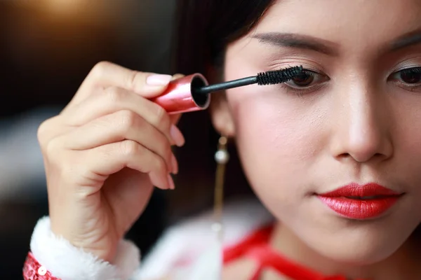 Young asian santa girl applying eye shadow on beautiful face — Stock Photo, Image