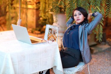 restoran veya kafeden dizüstü bilgisayar üzerinde çalışan gözlüklü sevimli ve büyüleyici iş kadını