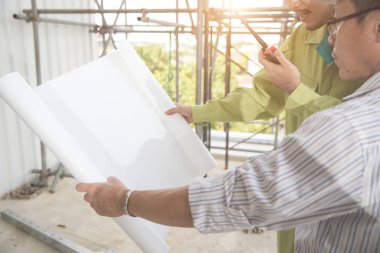 şantiyede mimarlık veya plan ile çalışan ve tartışan mühendis insanlar