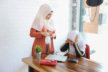 o ahşap masada bilgisayar ve kahve fincanı ile geç çalışan çalışan beacause gösteren ve şikayetçi çalışan müslüman patron