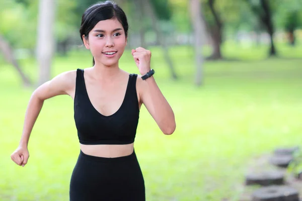 Jovem mulher saudável e desportiva correndo no parque — Fotografia de Stock