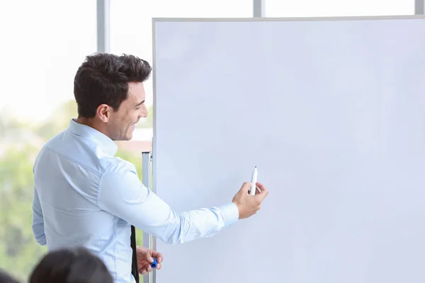 takım toplantısında veya antrenmanında kafkas işadamı koçluğu, boş beyaz tahtaya bir şeyler çizen konuşmacı (iş semineri konsepti)
