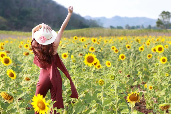 Портрет красивої жінки, яка має щасливий час і насолоджується серед соняшникового поля в природі — стокове фото