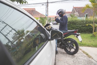 araba veya para çalmaya çalışırken motosiklet üzerinde silah ile hırsız (hırsızlık kavramı)