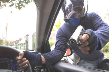 araba veya para çalmaya çalışırken motosiklet üzerinde silah ile hırsız (hırsızlık kavramı)