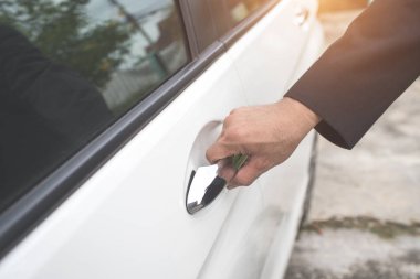 araba kapısını açmak için uzaktan kumanda kullanan işadamı