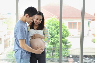genç asyalı koca kucaklayan ve sevgi ve gülümseme ile genç hamile göbek asya karısı dokunmadan